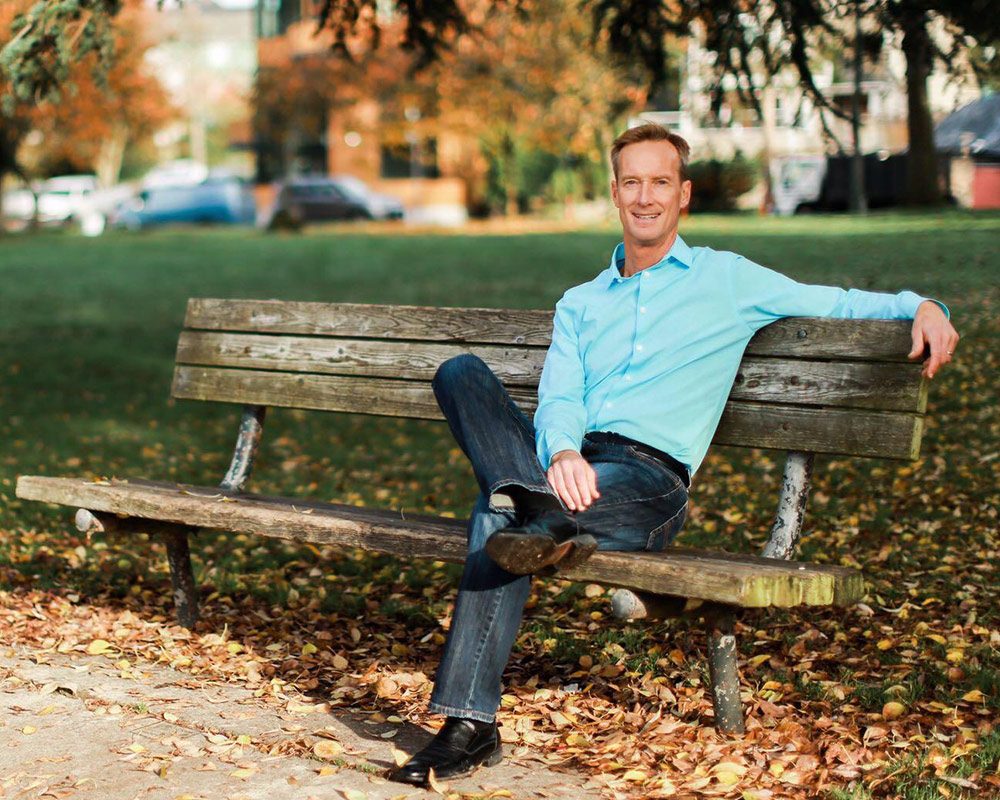 photo of Dr. Ramaley sitting on a park bench in Seattle