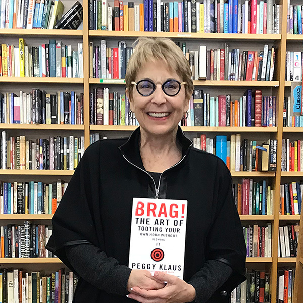 Peggy Klaus holding her book "Brag! The Art of Tooting Your Own Horn Without Blowing It"