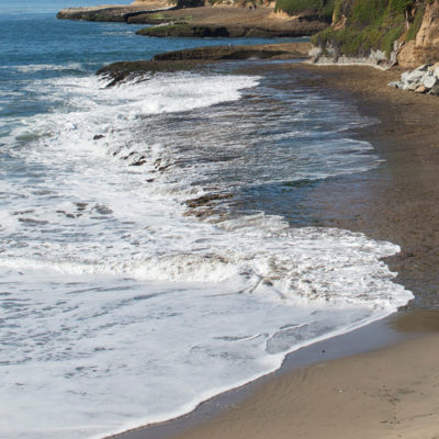 photo of waves lapping up at the shore on the CA coast