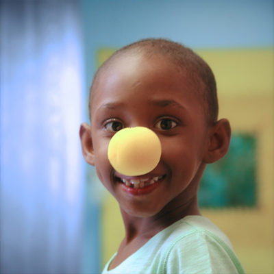 photo of a beautiful young girl with a clown nose